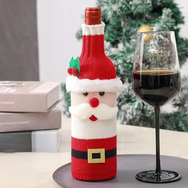 TK-H Merchandise Santa Claus knitted wine bottle cover with festive holly detail on a table next to a wine glass