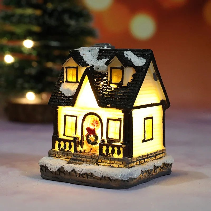Decorative house-shaped light with snow on the roof, glowing warmly against a blurred background.