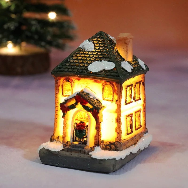 Decorative lit house with snow on the roof, surrounded by a warm glow.